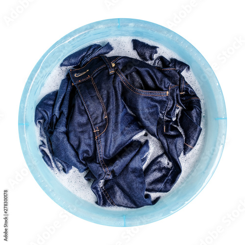 Blue jeans with liquid detergent in the plastic basin isolated on white background photo