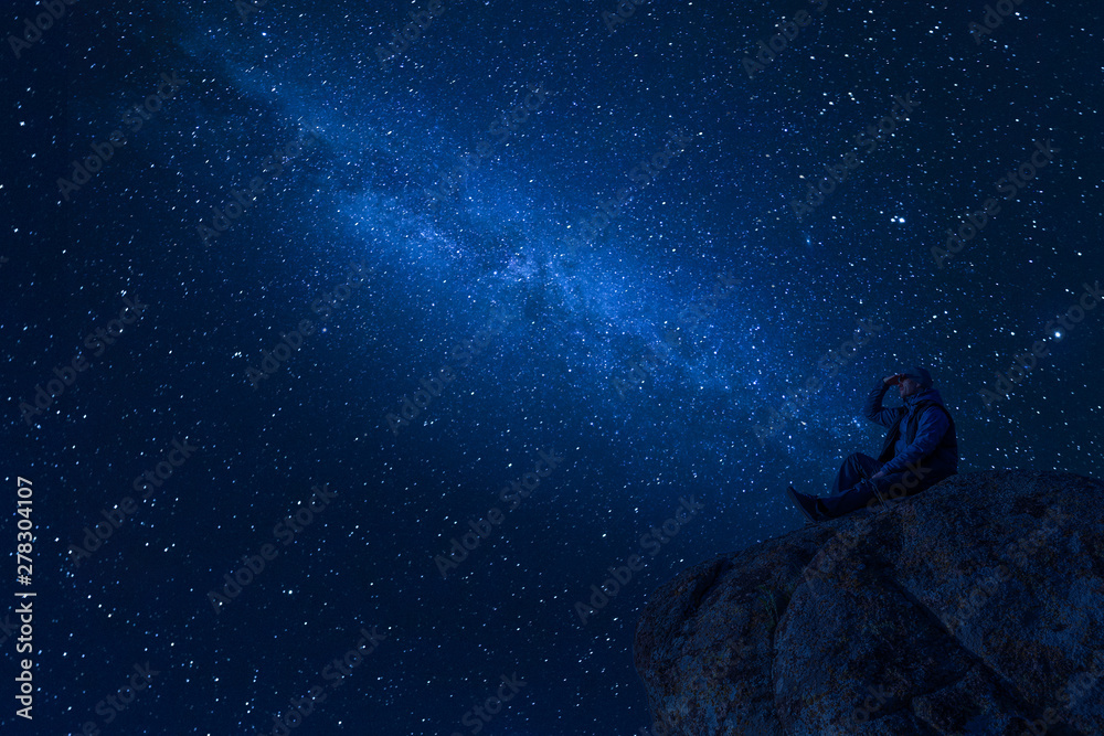 Fototapeta premium Mountaineer look at night sky with stars