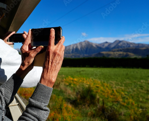 People taking Photos using their Smartphone from a Train