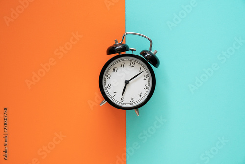Retro alarm clock on color table background, vintage style
