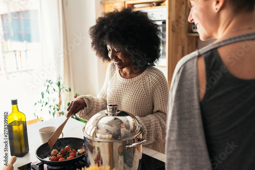 Two beautiful girls cooking in them home. photo