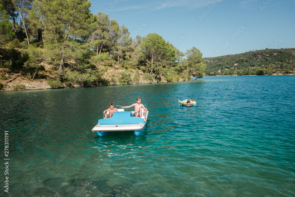 two boys on a boat and two girl in floats two boys on a boat and two girl in floats