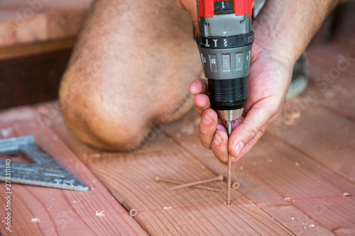 Man using a drill to build a deck