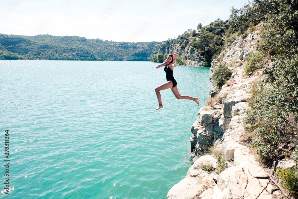 teen girl jumping off cliff in a lake in Provence Stock Photo Adobe Stock