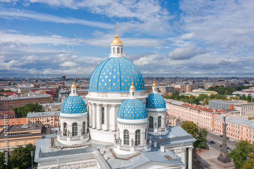 The famous Trinity Cathedral with blue domes and gilded stars, view of the historic part of the city of Staint-Petersburg, typical houses around. photo