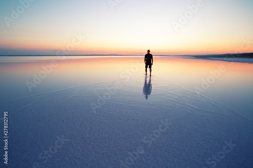 Fototapeta Naklejka Na Ścianę i Meble -  Salt lake Tuz with man leaving at sunset
