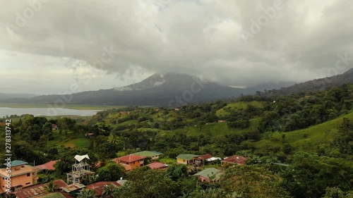 Aerial Footage tracking forward through El Castillo village in Costa Rica with Arenal Volcano and Lake in the distance photo