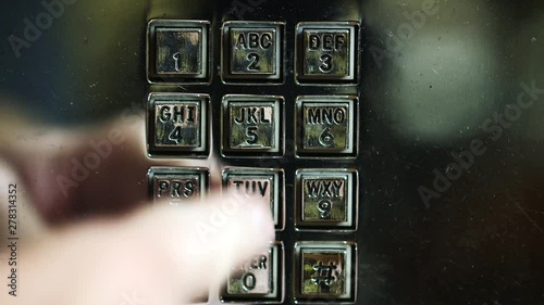 Close up, dialing on payphone
