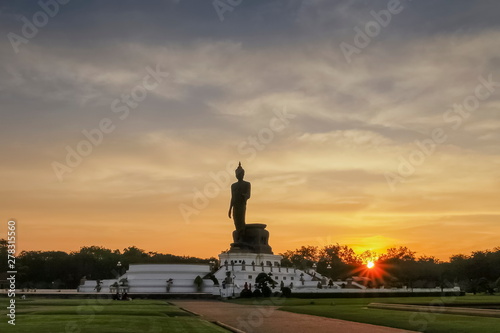 Silhouette walking buddha statue with yellow sky and sunset background, Phutthamonthon is a Buddhist park in the Phutthamonthon District, Nakhon Pathom Province of Thailand,