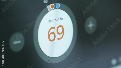 Close up, person sets electronic thermostat