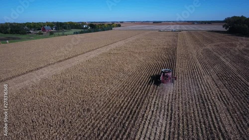Aerial, farm harvester in field