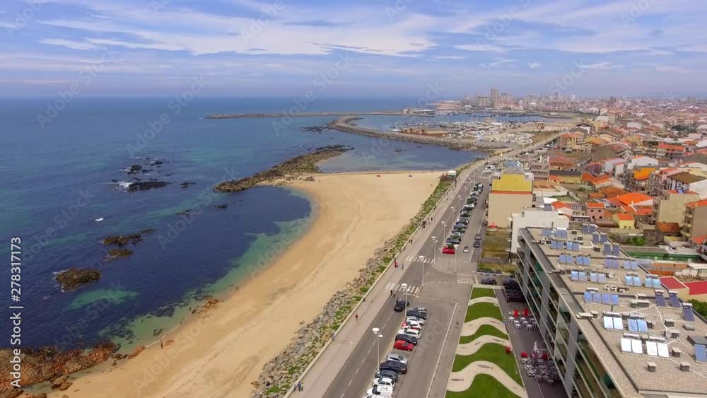 Aerial, descending, drone shot, of the Praia dos Barcos beach, the sea, and buildings on the coast of Vila do Conde, on a sunny, summer morning. near Porto, Portugal Aerial, descending, drone shot, of the Praia dos Barcos beach, the sea, and buildings on the coast of Vila do Conde, on a sunny, summer morning. near Porto, Portugal