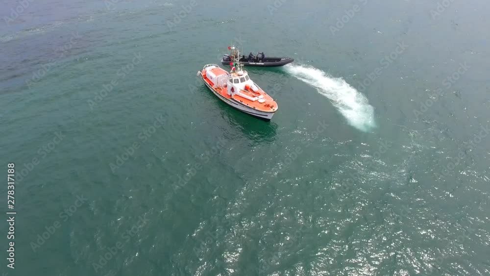 Aerial, reverse, drone shot, tilting away from a rib boat and other boats, on the coast of Vila do Conde, on a sunny, summer morning. near Porto, in Portugal Aerial, reverse, drone shot, tilting away from a rib boat and other boats, on the coast of Vila do Conde, on a sunny, summer morning. near Porto, in Portugal