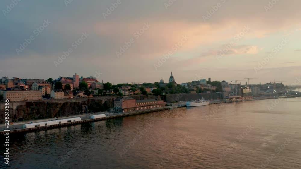 Aerial panning shot across Stockholm waterfront harbour buildings during sunset golden hour. Aerial panning shot across Stockholm waterfront harbour buildings during sunset golden hour.