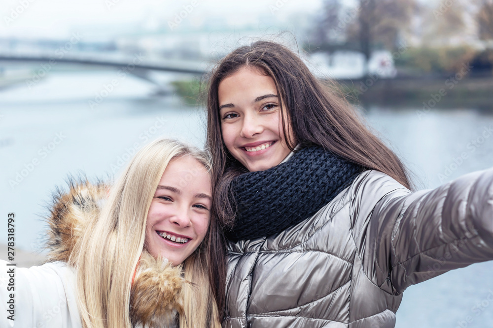 Fototapeta premium young attractive teen girls laugh while taking selfie together