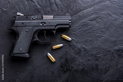 Gun with tablet on dark background.