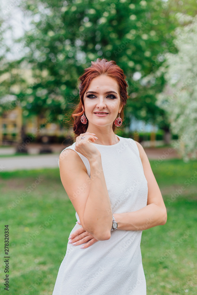 Charming woman wearing beautiful white dress under the apple tree Charming woman wearing beautiful white dress under the apple tree