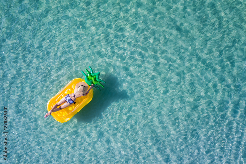 op aerial view of young woman enjoy swimming on floating inflatable tube in sea with cleared water, happy in summertime and vacation or long weekend swimming at sea .