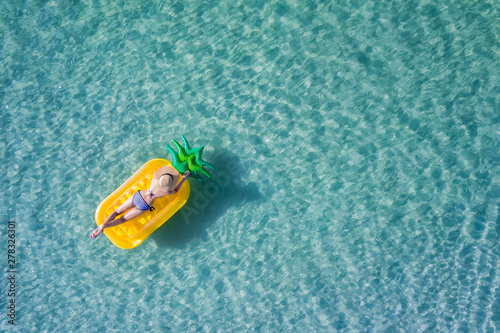 op aerial view of young woman enjoy swimming on floating inflatable tube in sea with cleared water, happy in summertime and vacation or long weekend swimming at sea .