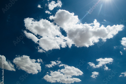 sun on the background of a blue sky with white clouds
