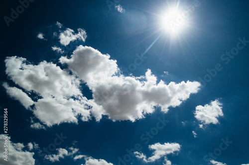 sun on the background of a blue sky with white clouds