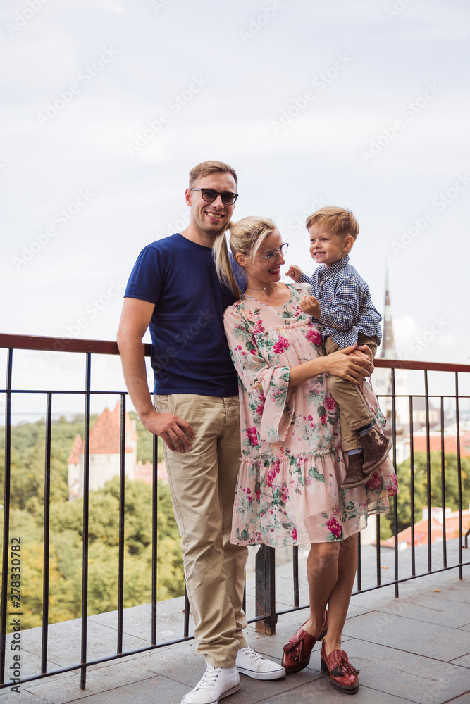 Naklejka premium The smiling lovely family standing against the background of the view on the city