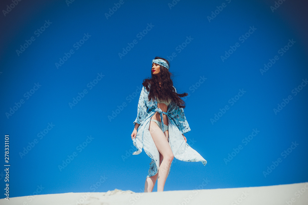 A young beautiful woman in beachwear and a ribbon on her head A young beautiful woman in beachwear and a ribbon on her head