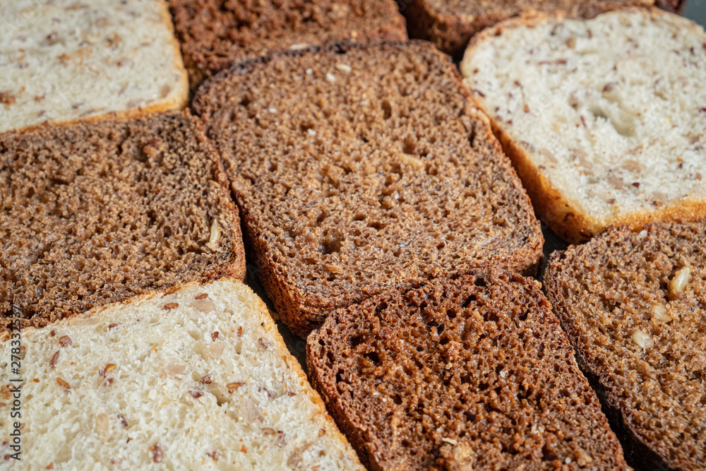 Close-up view of wholmeal bread slices, pattern effect. Whole-grain bread with visible detailed texture, diverse types Close-up view of wholmeal bread slices, pattern effect. Whole-grain bread with visible detailed texture, diverse types