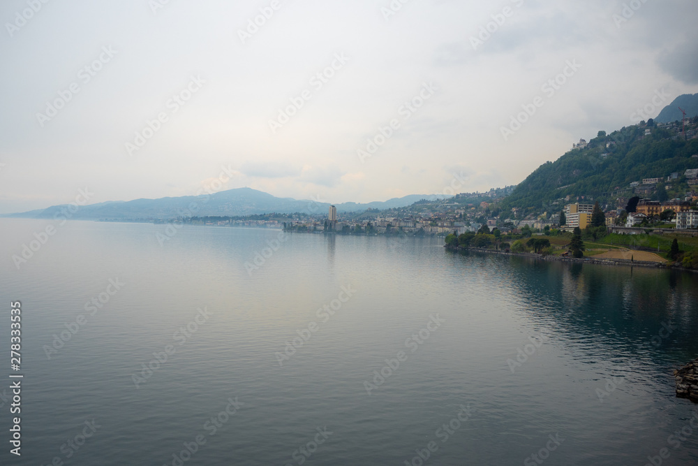Beautiful panorama view of Geneva lake and small village on mountain and cloudy sky background with copy space