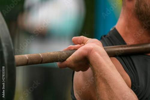 Hand of an athlete gripping a barbell on a crossfit event
