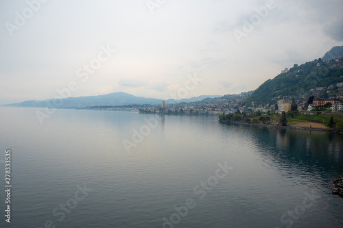 Beautiful panorama view of Geneva lake and small village on mountain and cloudy sky background with copy space