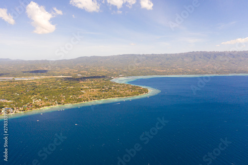 Coast of Cebu island, Moalboal, Philippines, top view. Philippine boats in a blue lagoon over coral reefs. Moalboal is a great place for diving and vacations.