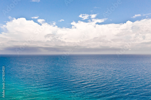 Seascape with clouds by day, view from above. Big white clouds over the sea.