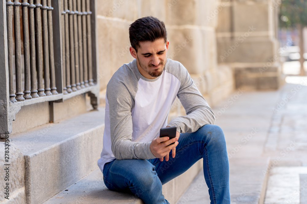 Young man reacting in social media network with a dislike rating Young man reacting in social media network with a dislike rating