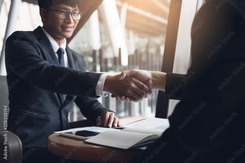 Two businessmen are talking and making deals on business operations and agreeing by shaking hands in the office. Two businessmen are talking and making deals on business operations and agreeing by shaking hands in the office.