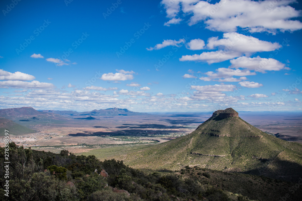 Mountain in the Valley of Desolation in Matjiesfontein, Graaf-Reinet, South Africa - with Rich Blue Sky and White Clouds Shadowing The Valley.