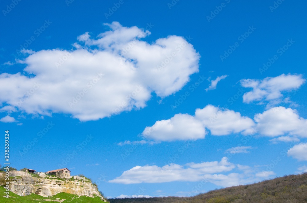 clouds over mountain. Old house in mountain 
