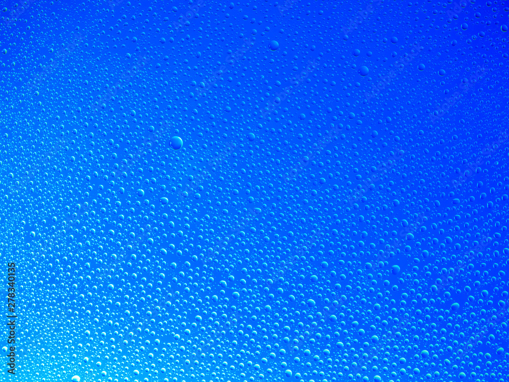 Water droplets on the glass with a colored background. Drops of water.