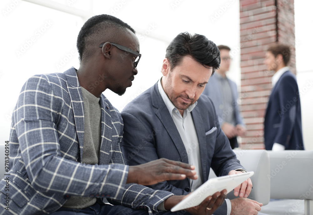 Obraz premium two business partners use a digital tablet.