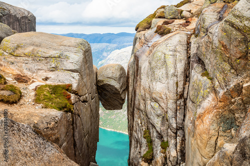 Kjeragbolten, the stone stuck between two rocks with fjord in the background, Lysefjord, Norway photo