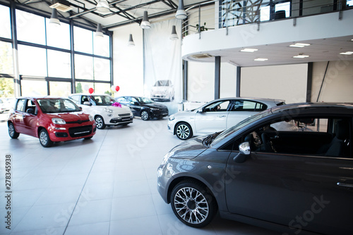 Car dealership showroom interior with brand new vehicles for sale. photo