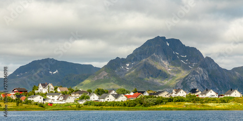 Norwegian houses and cottages at the lake with mountain in the background, Leknes, Vestvagoy Municipality, Nordland county, Norway photo