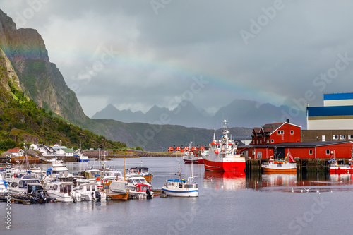Yachts and boats with mountain in the background and rainbow arc at pier in Svolvaer, Lototen islands, Austvagoya, Vagan Municipality, Nordland County, Norway photo