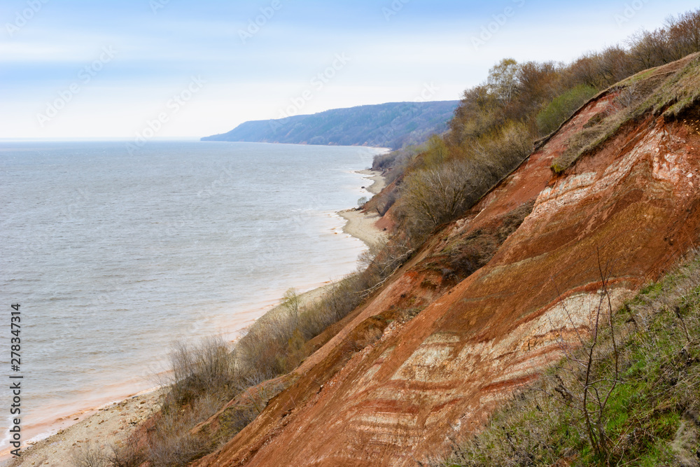 Stony, pebble and clay banks of the Volga River. Mountain slope of various stone rocks. Spring cloudy day with rain. Beautiful spring landscape. Tetyushi, Tatarstan. Stony, pebble and clay banks of the Volga River. Mountain slope of various stone rocks. Spring cloudy day with rain. Beautiful spring landscape. Tetyushi, Tatarstan.