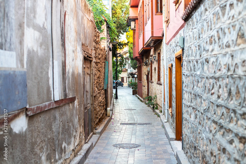 Narrow alley in the old town. Curved walls of houses in a narrow street. Old walls and doors in a narrow passage of a European small town © Mikhail