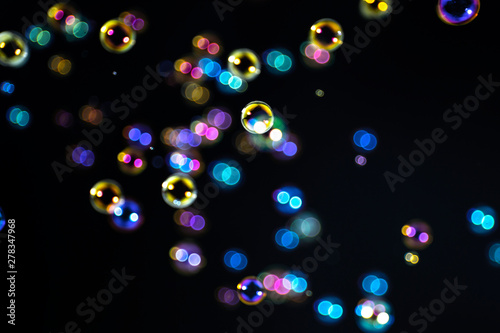 beautiful rainbow colorful of soap bubbles floating on black background.