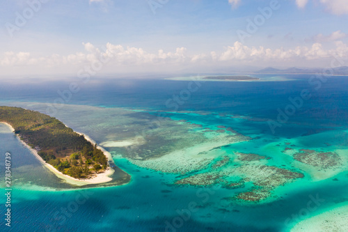 Canabungan Island with sandy beach. Tropical island with white beach on the large atoll, aerial view. Seascape, Philippine Islands.