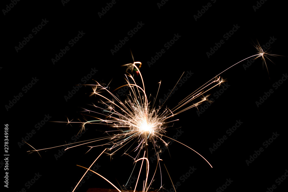 Sparkler on black background; fire sparks particles on black background for overlay design; the sparks source located on center; long traces