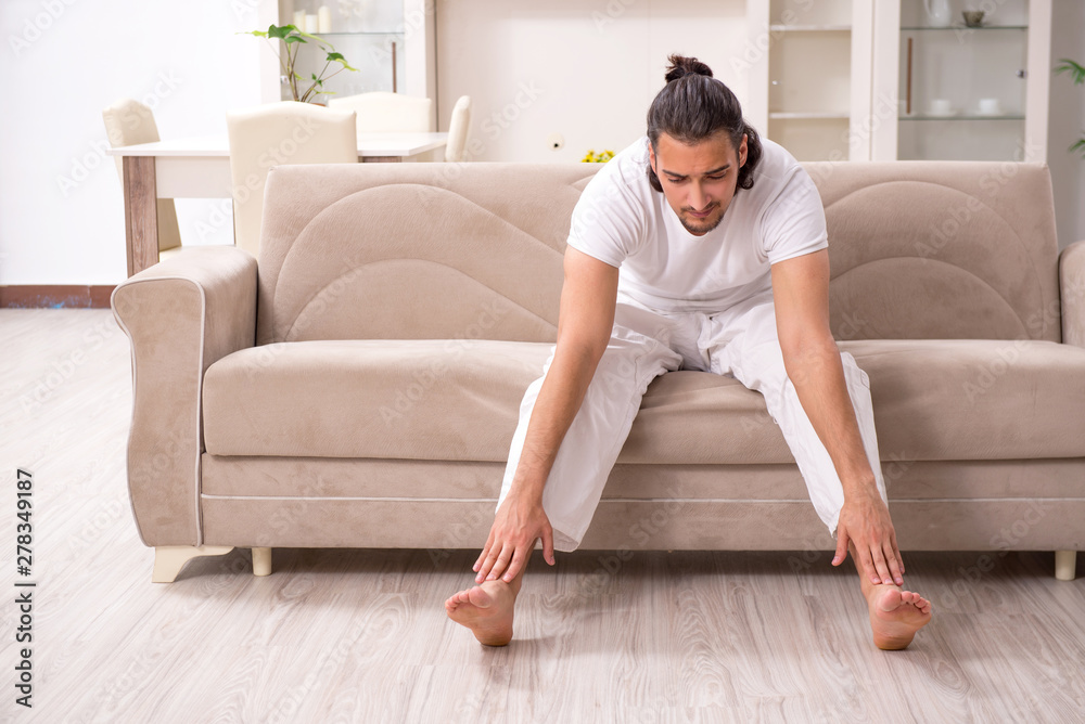 Young man doing physical exercises at home Young man doing physical exercises at home