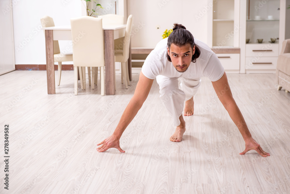Young man doing physical exercises at home Young man doing physical exercises at home